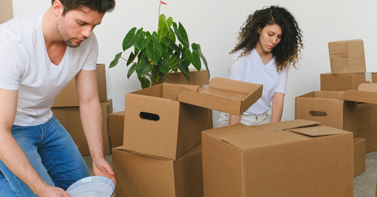 Young Couple Packing While Relocating in New Flat Young Couple Packing While Relocating in New Flat